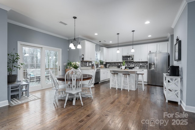 dining room featuring crown molding, dark hardwood / wood-style flooring, and an inviting chandelier