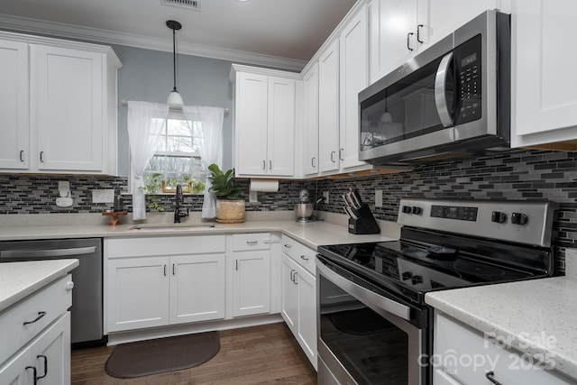 kitchen with backsplash, sink, appliances with stainless steel finishes, decorative light fixtures, and white cabinetry