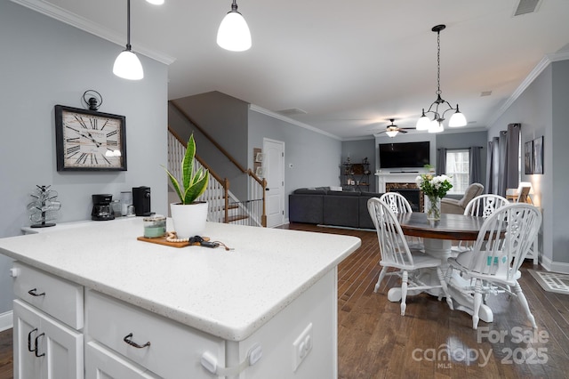 kitchen featuring white cabinets, a center island, pendant lighting, and ceiling fan