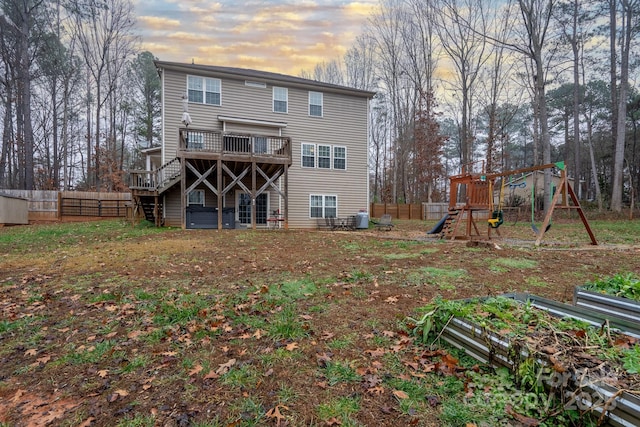 back house at dusk featuring a playground