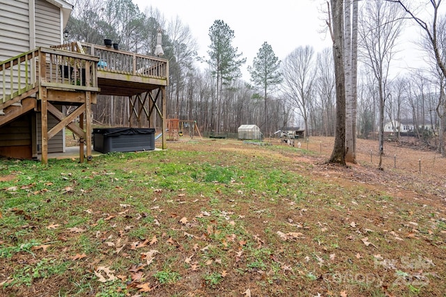 view of yard featuring a wooden deck and a hot tub