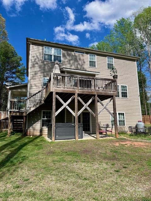 123 Kingfisher Dr, Mooresville, NC 28117 - back of house with a deck, a hot tub, a patio area, a lawn, and stairway