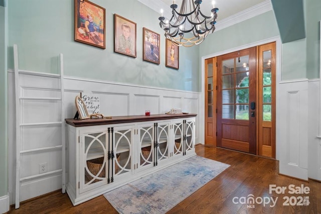 entrance foyer featuring crown molding, dark wood-type flooring, and a chandelier