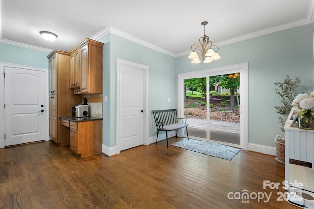 interior space featuring a chandelier, dark hardwood / wood-style flooring, and ornamental molding