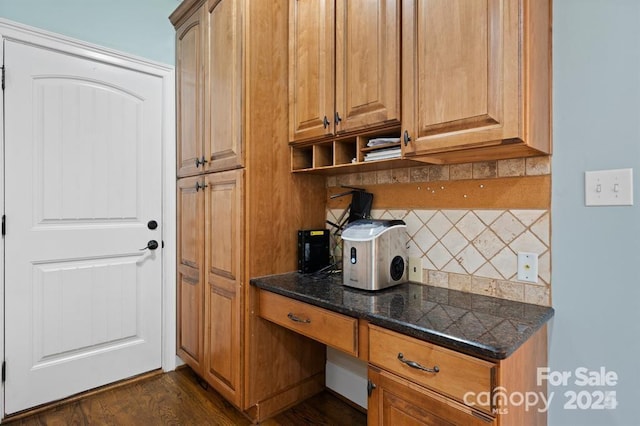 kitchen featuring decorative backsplash, dark hardwood / wood-style floors, and dark stone counters