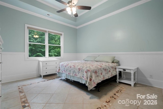 tiled bedroom with a tray ceiling, ceiling fan, and crown molding