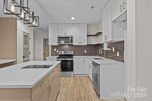 kitchen featuring white cabinets, hanging light fixtures, sink, and appliances with stainless steel finishes