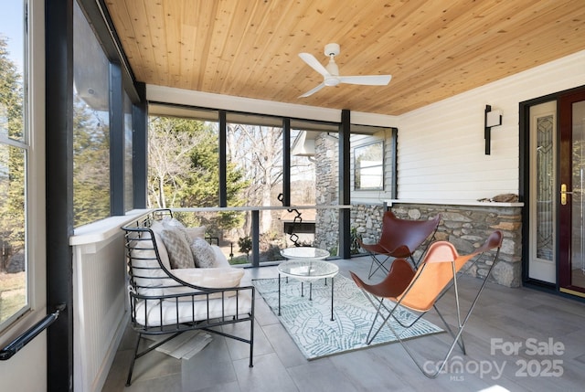 sunroom featuring wooden ceiling and a ceiling fan