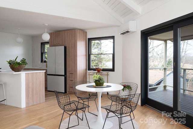 dining space with an AC wall unit, vaulted ceiling with beams, and light wood finished floors