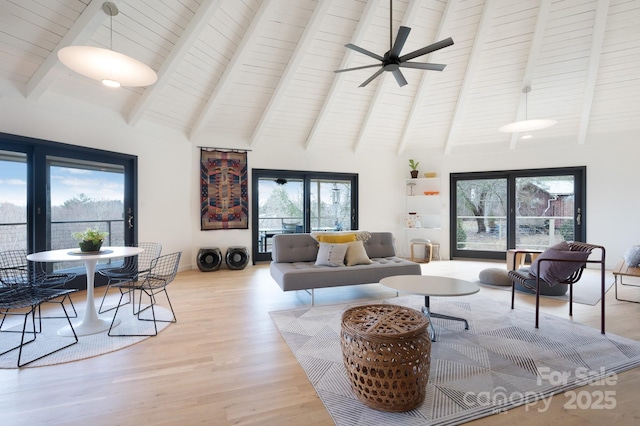 living room featuring beamed ceiling, high vaulted ceiling, a ceiling fan, and wood finished floors