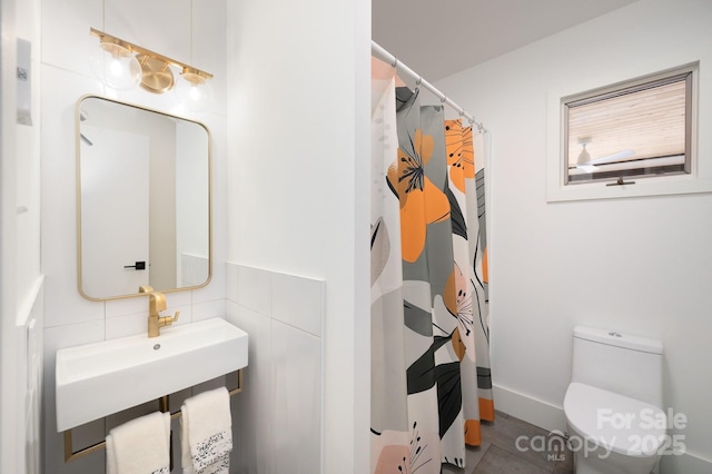 bathroom featuring curtained shower, tasteful backsplash, and toilet