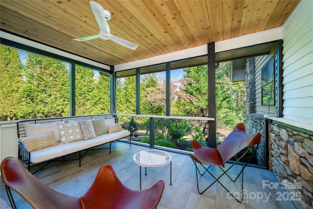 sunroom / solarium with a healthy amount of sunlight, wooden ceiling, and ceiling fan