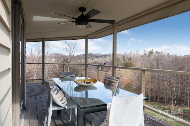 sunroom / solarium featuring a ceiling fan