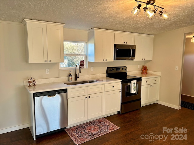 kitchen with white cabinetry, sink, dark hardwood / wood-style floors, a textured ceiling, and appliances with stainless steel finishes