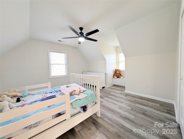 bedroom with ceiling fan, hardwood / wood-style floors, and vaulted ceiling