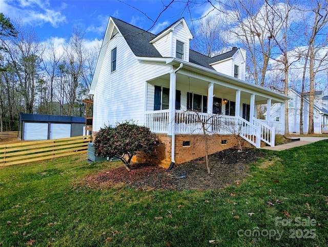 view of front facade featuring a garage, covered porch, an outdoor structure, and a front lawn