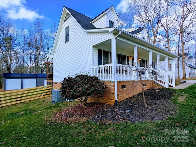 view of side of property with covered porch, a yard, an outdoor structure, and central air condition unit