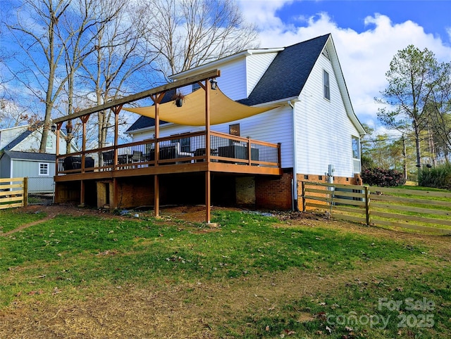 rear view of house with a yard and a deck