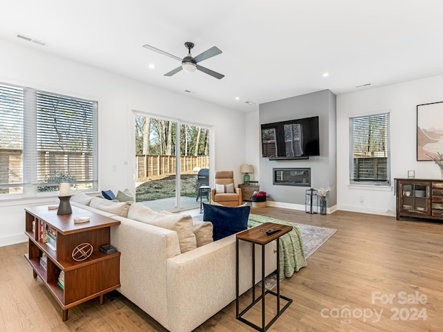 living room with ceiling fan and light hardwood / wood-style flooring