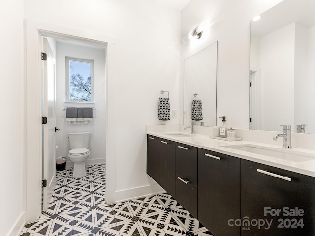 bathroom featuring tile patterned flooring, vanity, and toilet