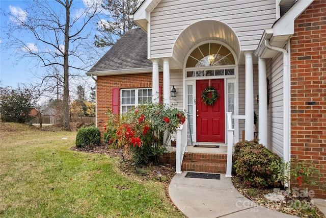 property entrance featuring a lawn