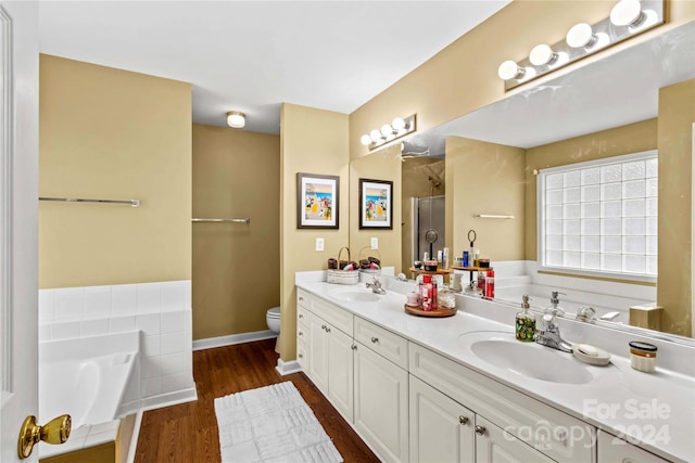 full bathroom with separate shower and tub, toilet, vanity, and hardwood / wood-style flooring