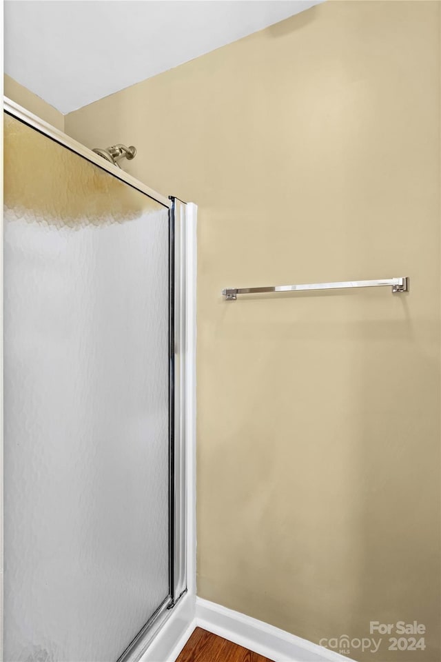 bathroom featuring a shower with door and hardwood / wood-style flooring