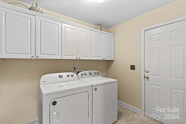 laundry area with washer and dryer and cabinets