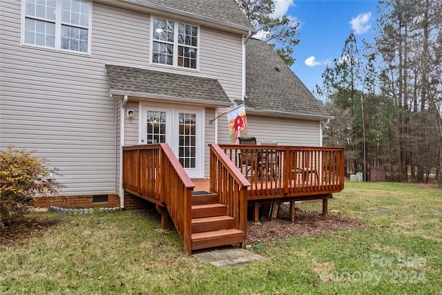 rear view of property featuring a wooden deck and a yard