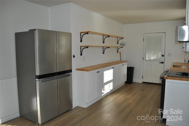 kitchen featuring white cabinets, stainless steel fridge, dark wood-type flooring, and sink