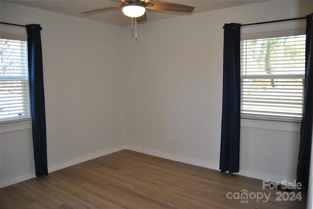 spare room featuring ceiling fan and dark wood-type flooring