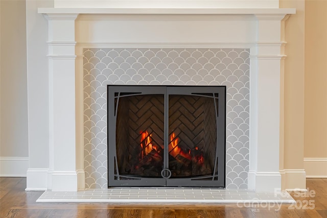 interior details featuring a fireplace, baseboards, and wood finished floors