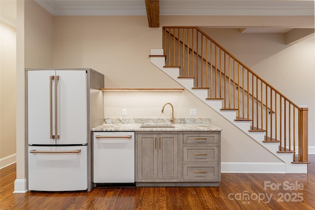 kitchen featuring white appliances, gray cabinetry, a sink, and dark wood-type flooring