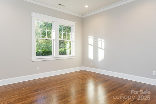 empty room featuring dark wood-type flooring, visible vents, recessed lighting, crown molding, and baseboards