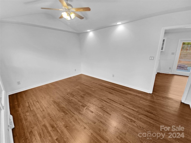 unfurnished room with vaulted ceiling, ceiling fan, and dark wood-type flooring