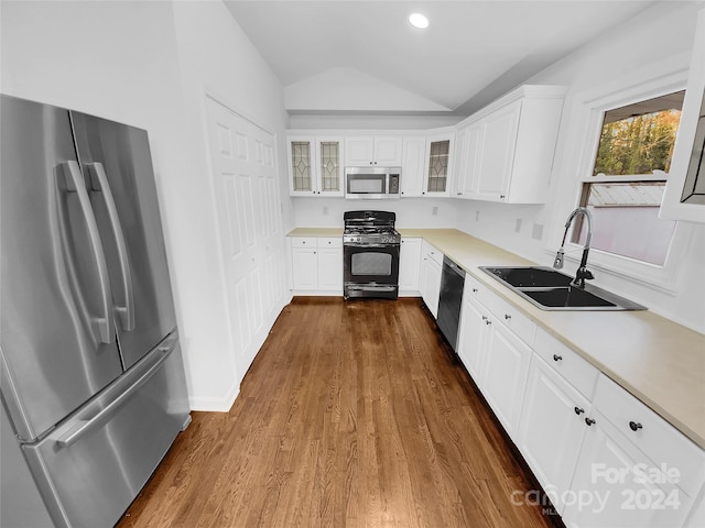 kitchen with white cabinetry, sink, dark wood-type flooring, stainless steel appliances, and lofted ceiling