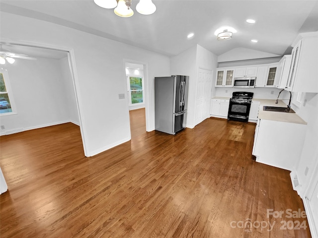 kitchen featuring sink, dark hardwood / wood-style flooring, lofted ceiling, white cabinets, and appliances with stainless steel finishes