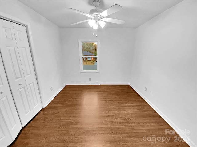 unfurnished bedroom featuring ceiling fan, dark wood-type flooring, and a closet