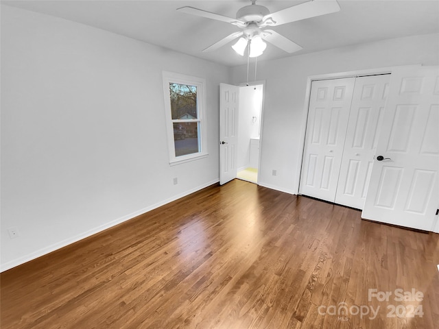 unfurnished bedroom featuring dark hardwood / wood-style flooring, a closet, and ceiling fan