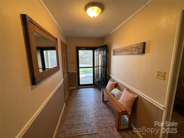 doorway featuring ornamental molding and a textured ceiling