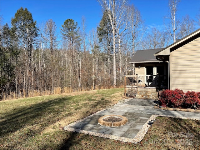 view of yard with a porch and a fire pit