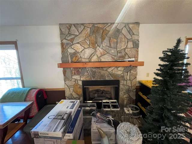 room details featuring a stone fireplace and a textured ceiling