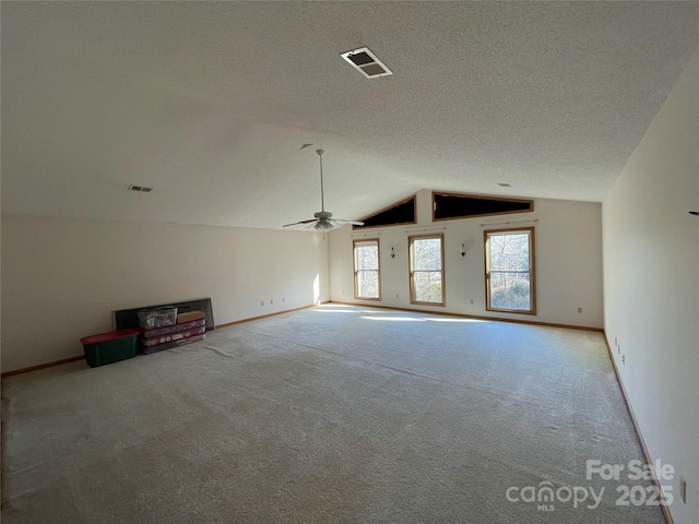 unfurnished living room with ceiling fan, lofted ceiling, carpet flooring, and a textured ceiling