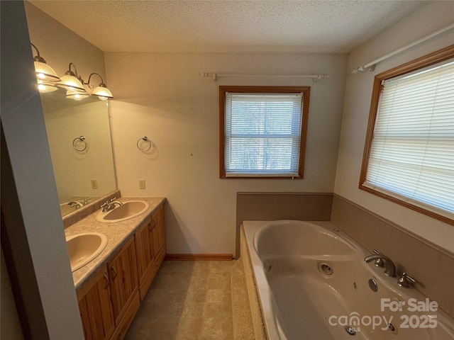 bathroom with vanity, a bath, and a textured ceiling