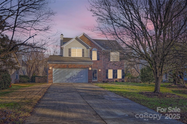 view of front of property featuring a garage and a lawn