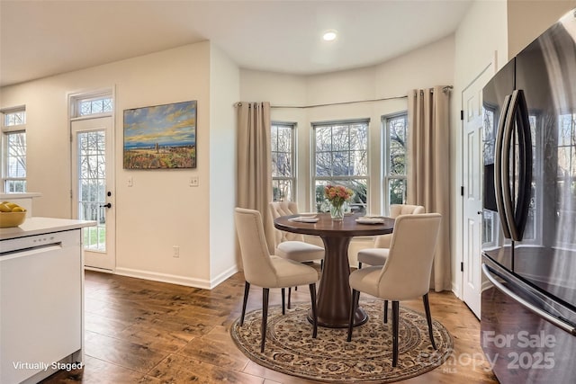 dining space with plenty of natural light and dark wood-type flooring