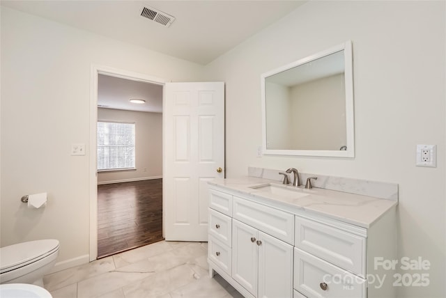 bathroom with vanity, toilet, and a bidet