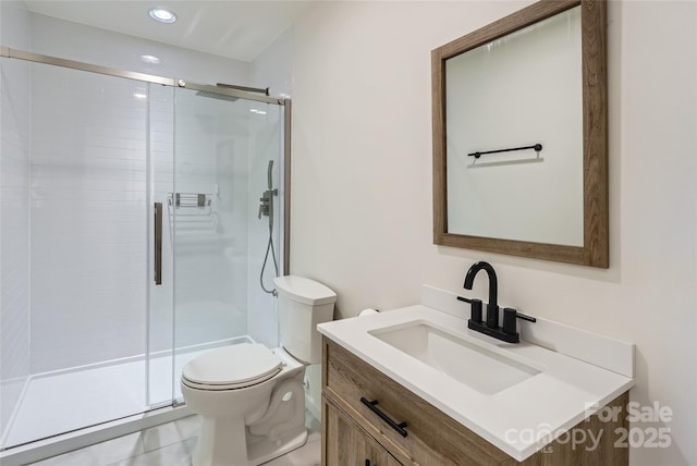 bathroom with tile patterned flooring, vanity, toilet, and a shower with shower door