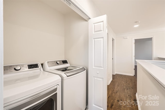 clothes washing area with separate washer and dryer and dark wood-type flooring