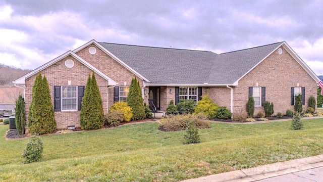 view of front of home with a front lawn and central air condition unit